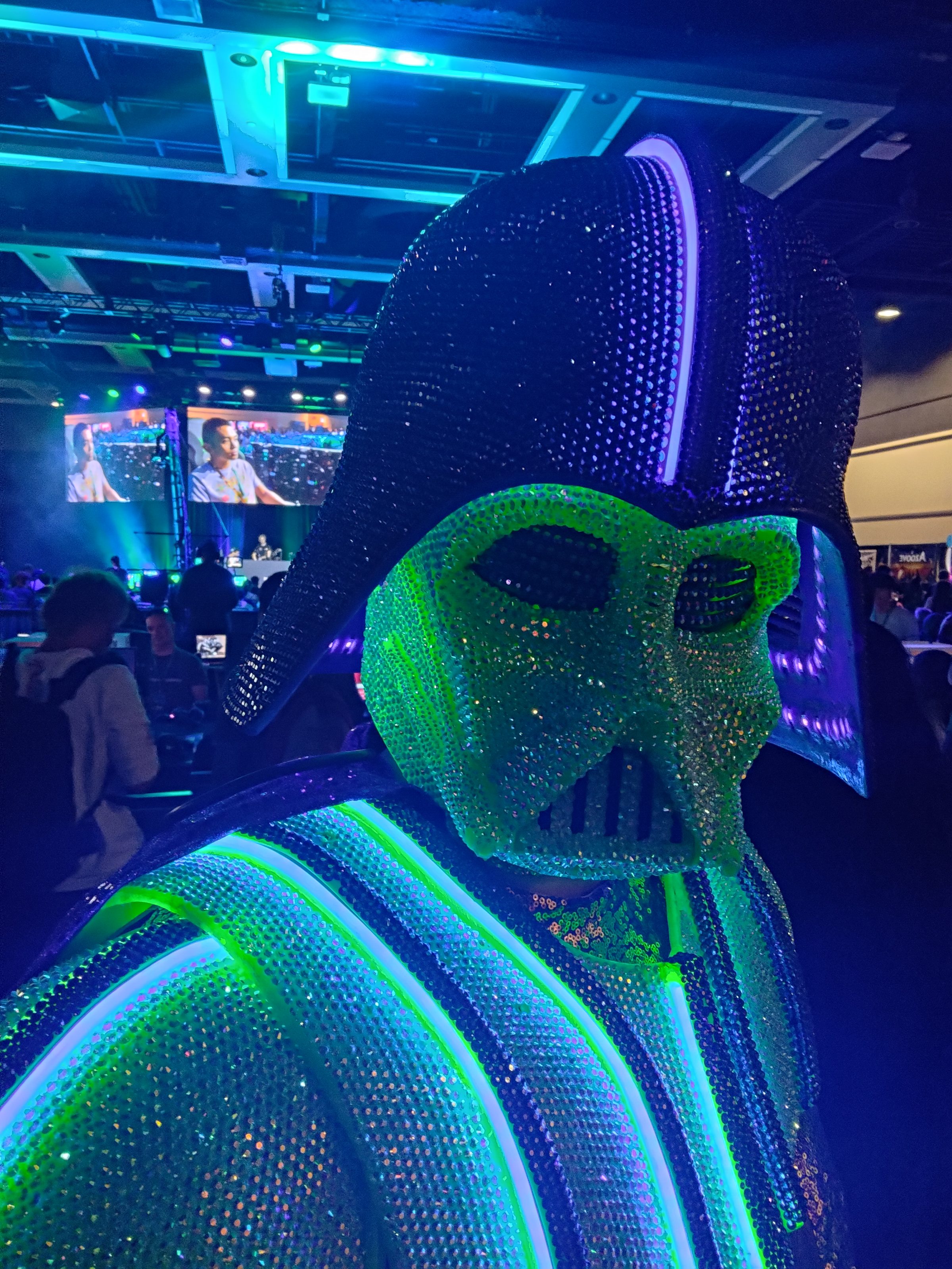 Close-up of the rhinestone-covered Darth Daddy helmet with green and blue light along its ridges.