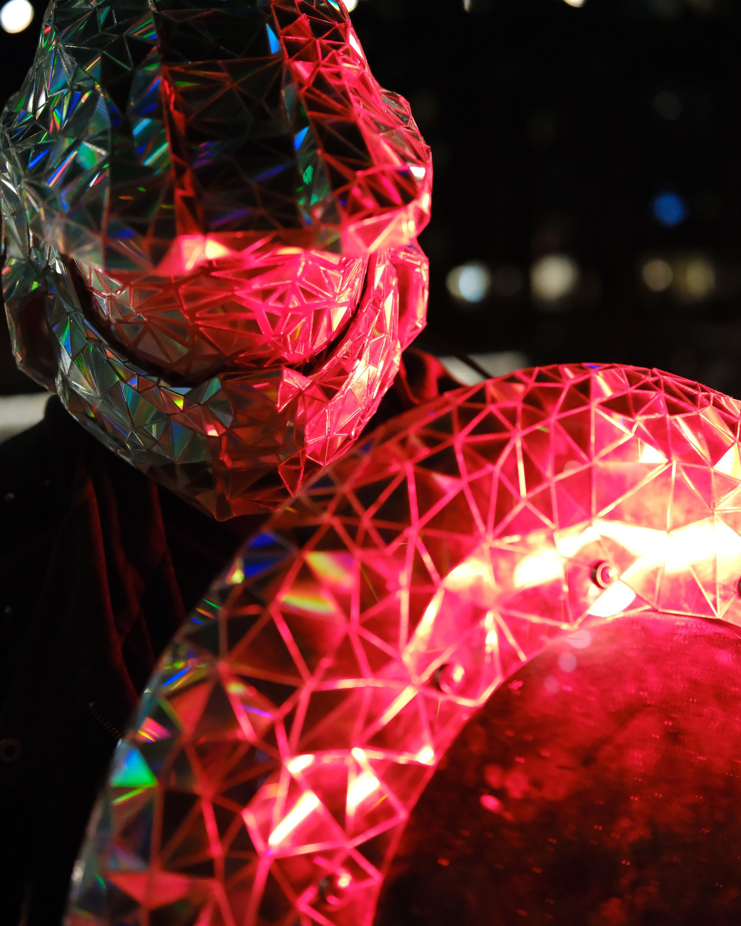 Tight crop of the helmet's faceted jaw beside the glowing rim of the shield.