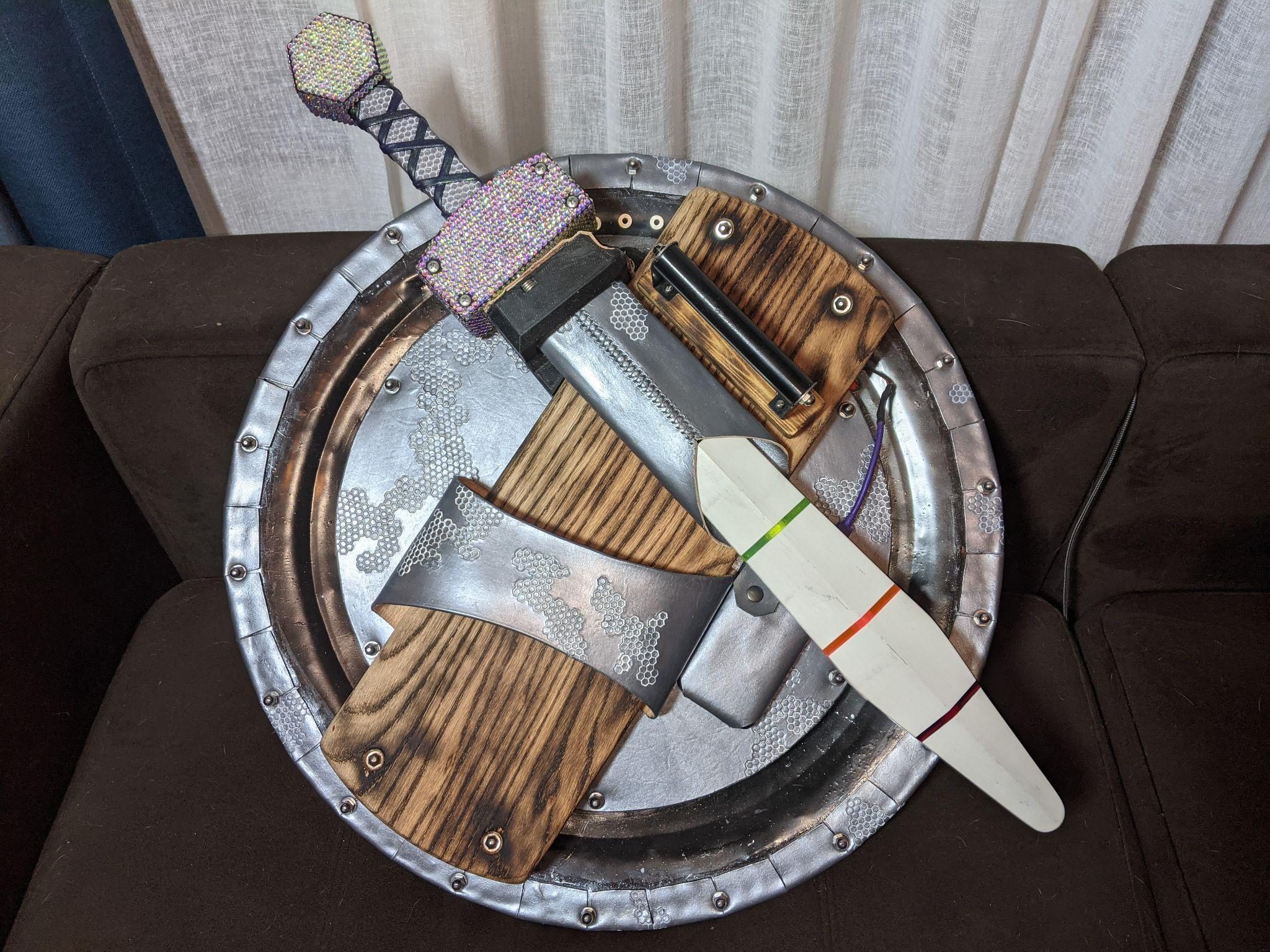 The back of the shield with the sword sheathed in its scabbard across the burnt oak arm bracket.