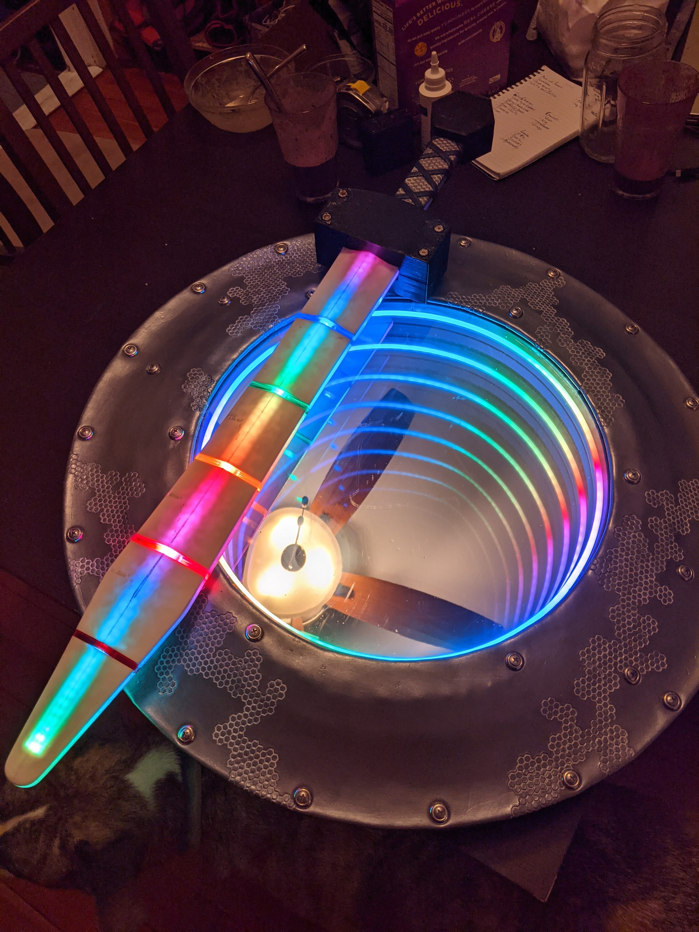 The shield and its glowing baton resting on a workbench under warm light.