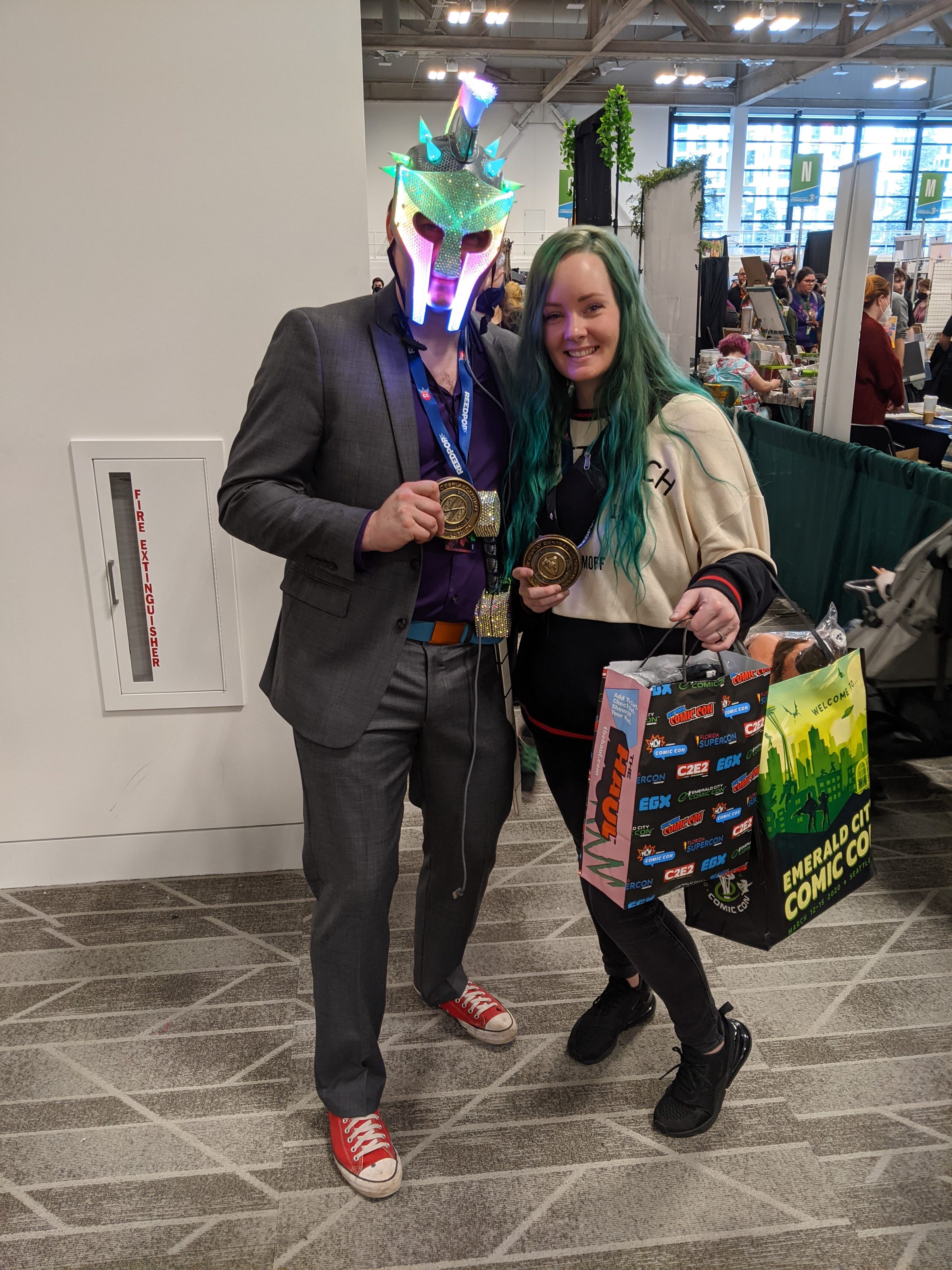 Wearing the Russell Glow helmet with a suit at a comic convention, standing with an attendee.