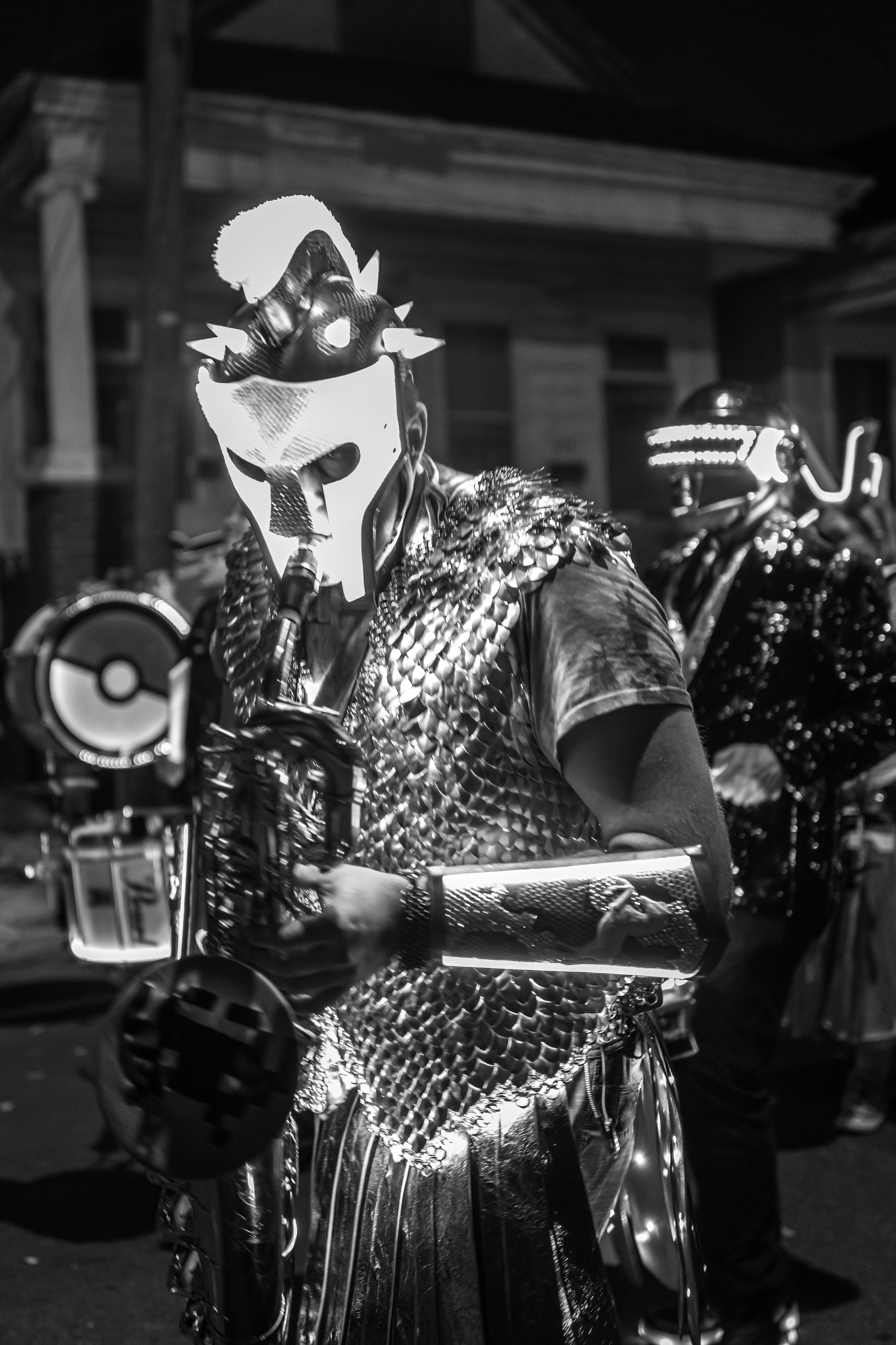 Black and white portrait of the Russell Glow helmet and armour during a night parade.