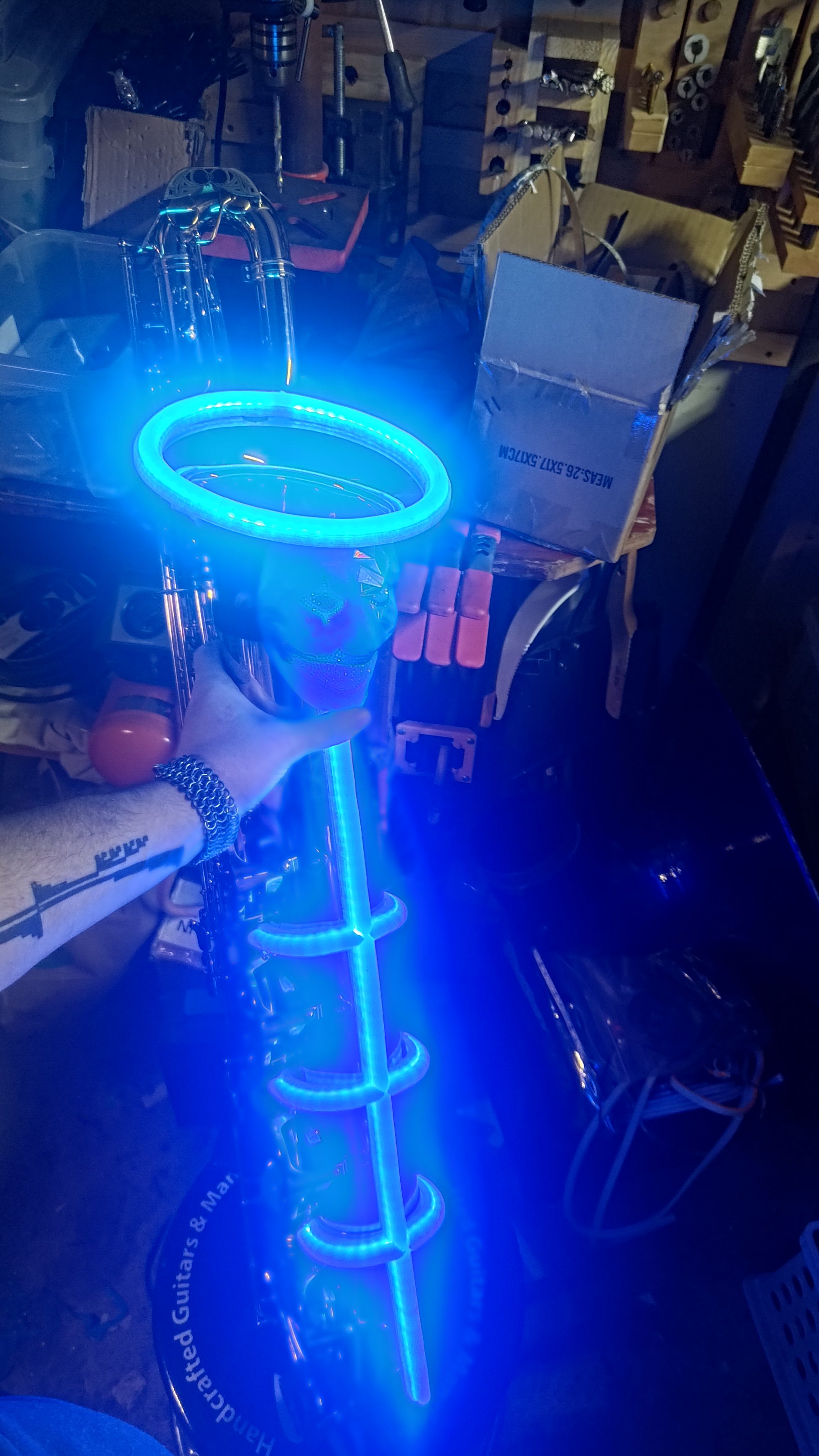 A saxophone wrapped in blue glowing rings and coils.