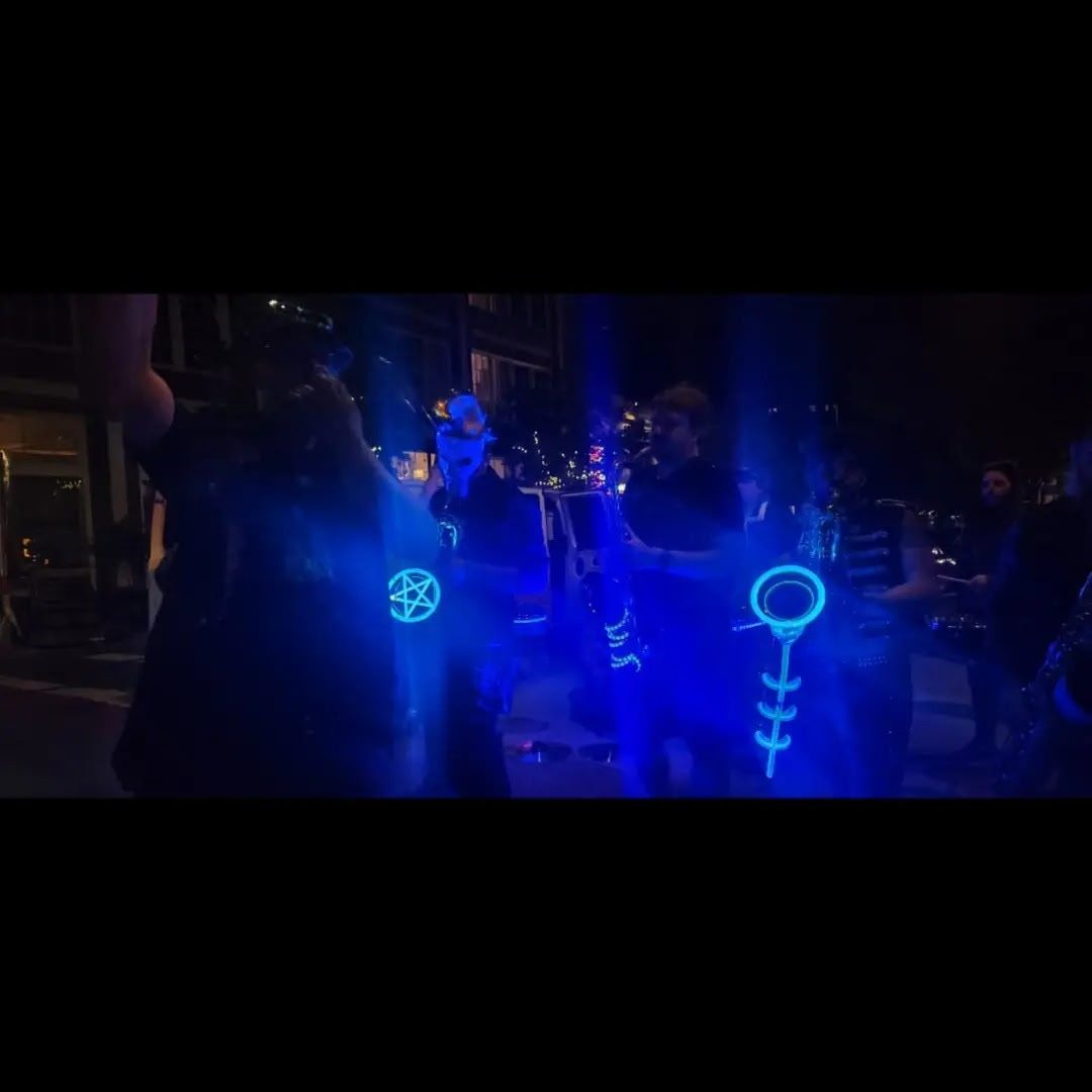 Glowing blue symbols lighting the players during a set in a dark venue.