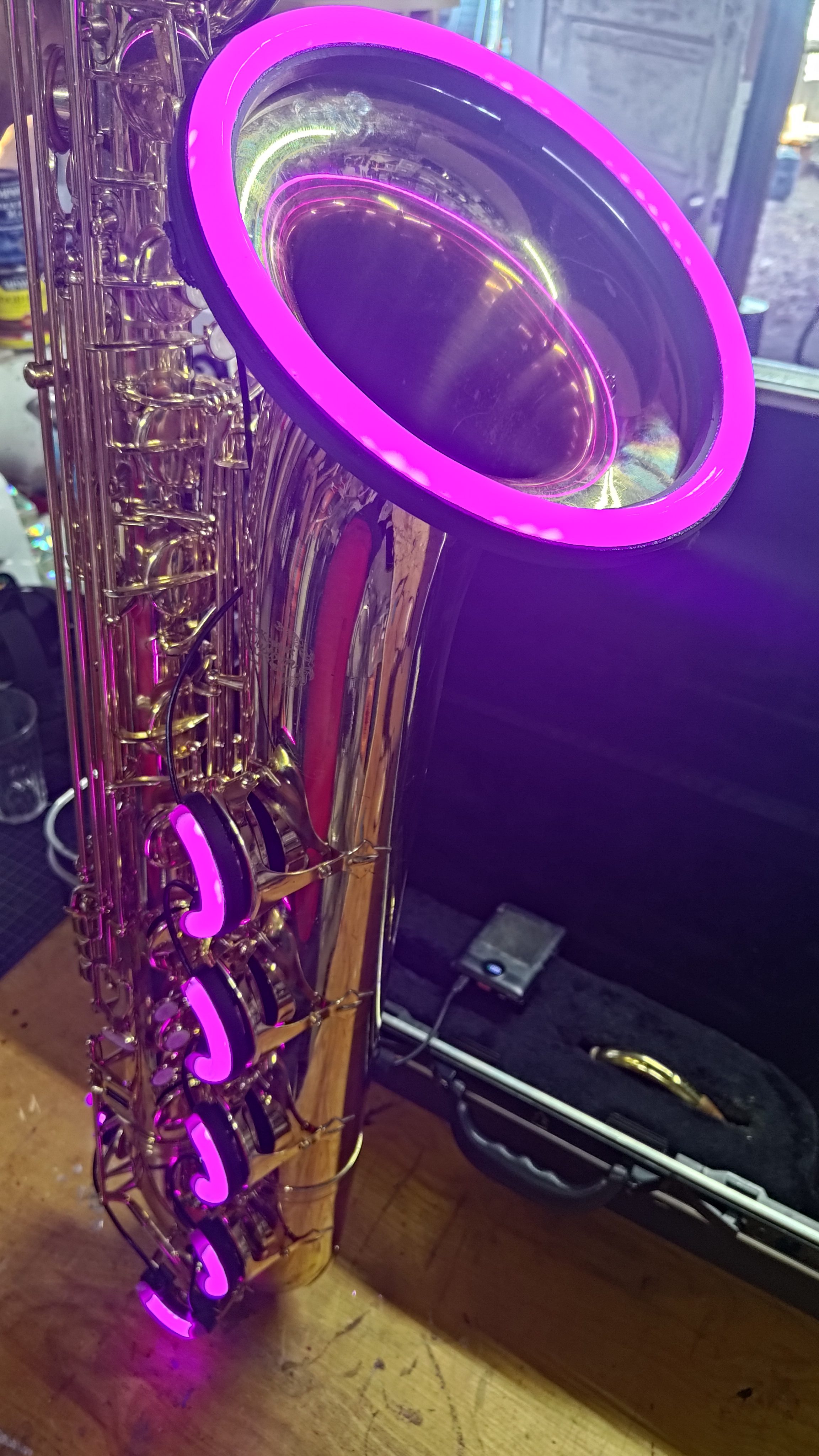 A saxophone bell circled by a magenta glowing ring.