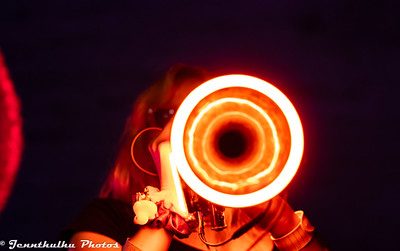 A glowing orange spiral ring photographed close up on stage.