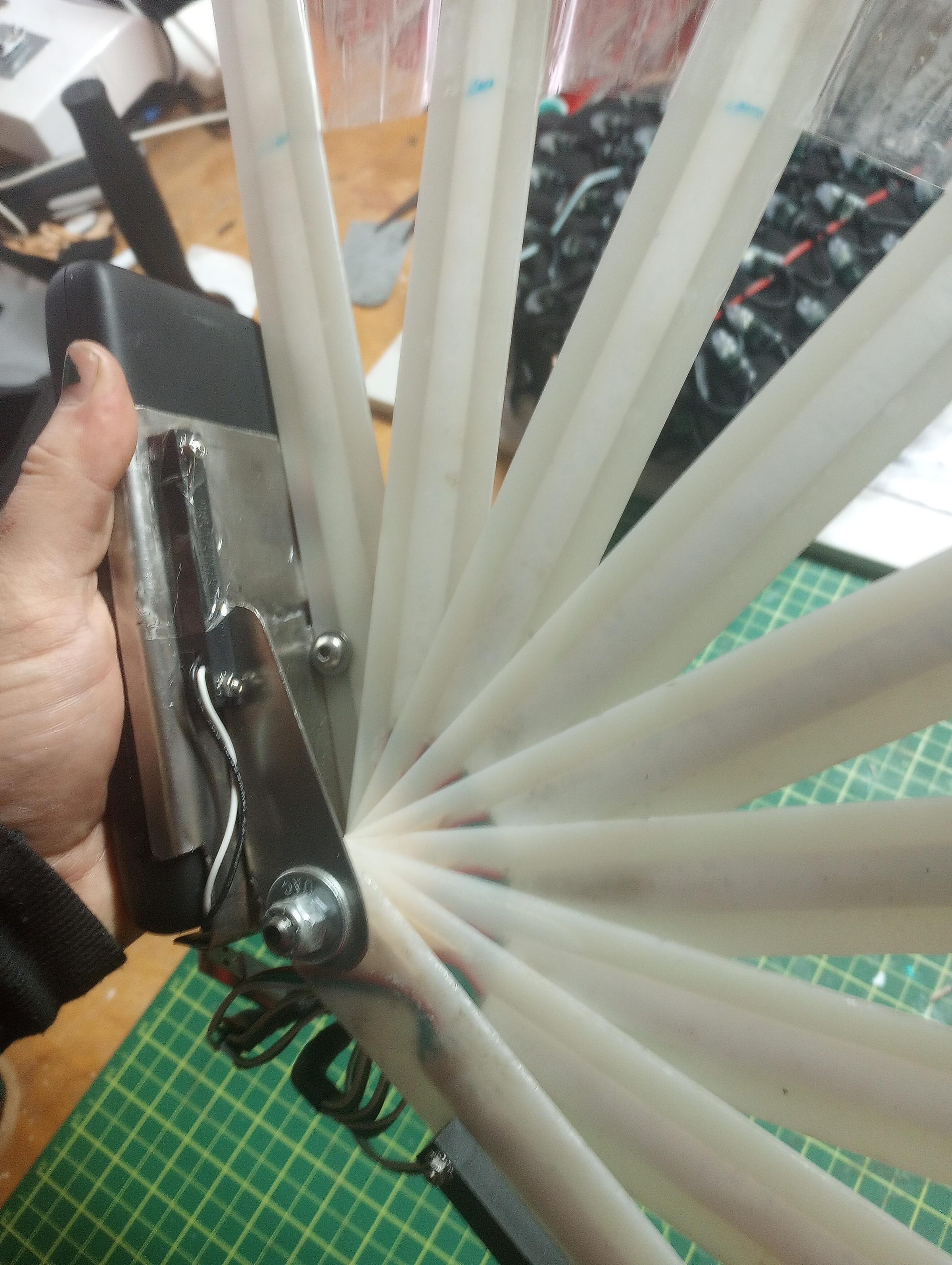 The hand fan's diffuser tubes fanned open, held in one hand.