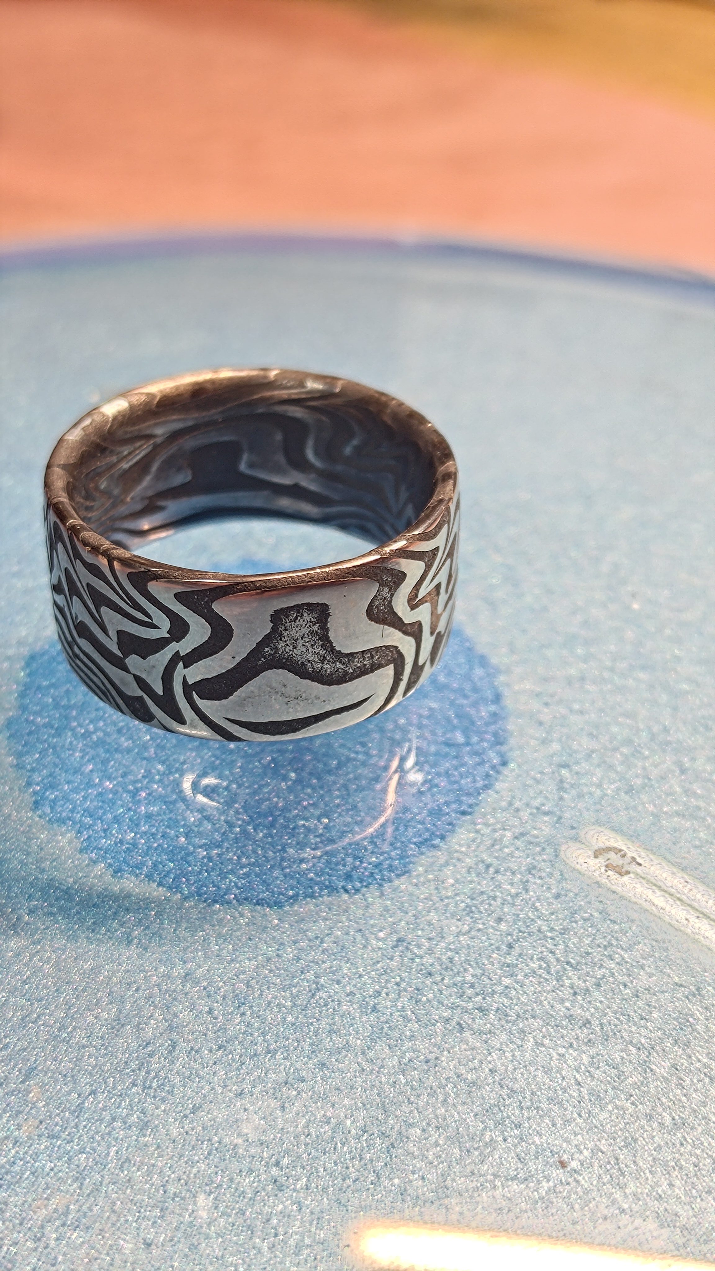 The same damascus ring on the blue dish, seen closer.