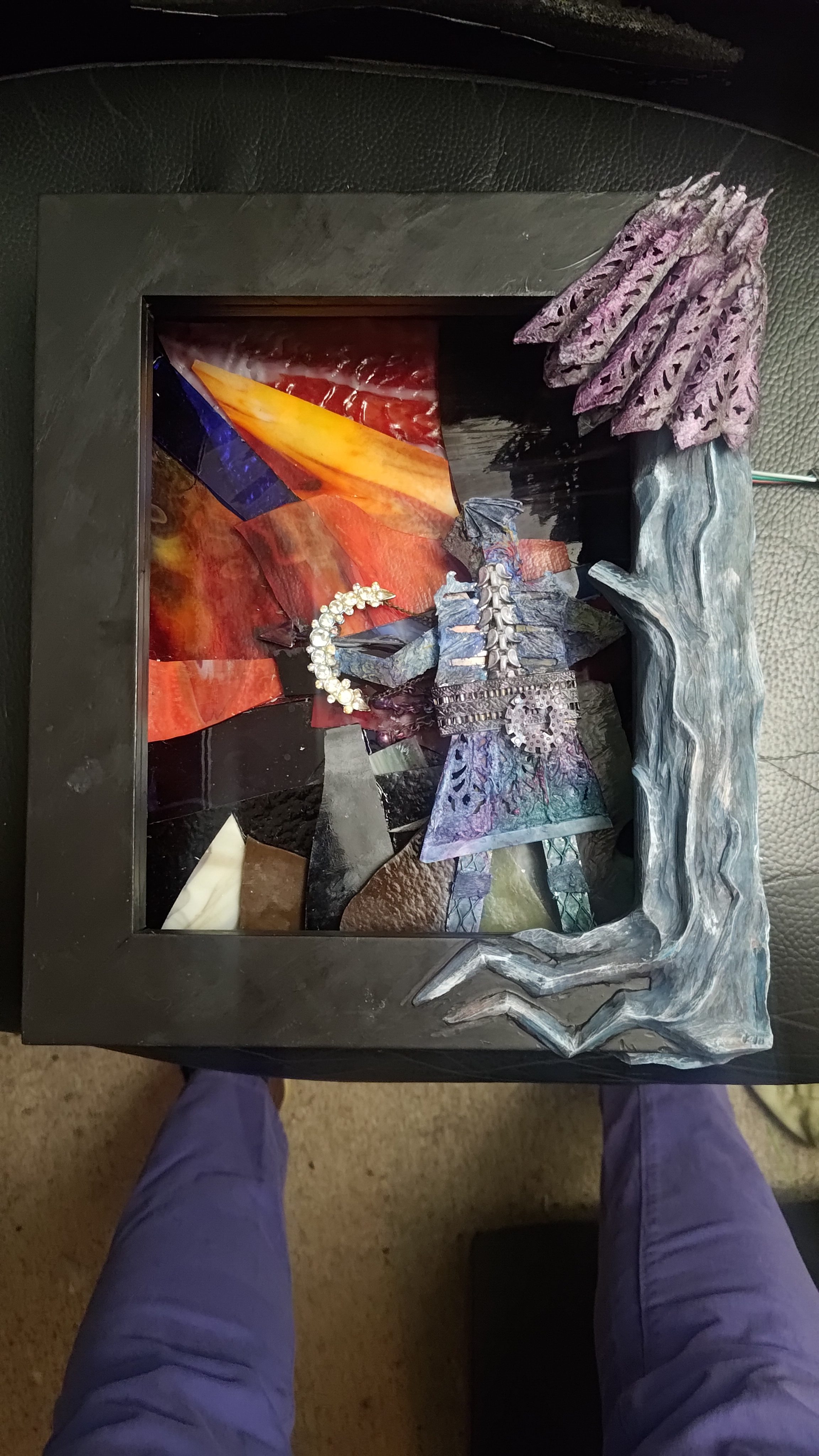 A framed panel of metal, glass, paint, and LEDs held upright.