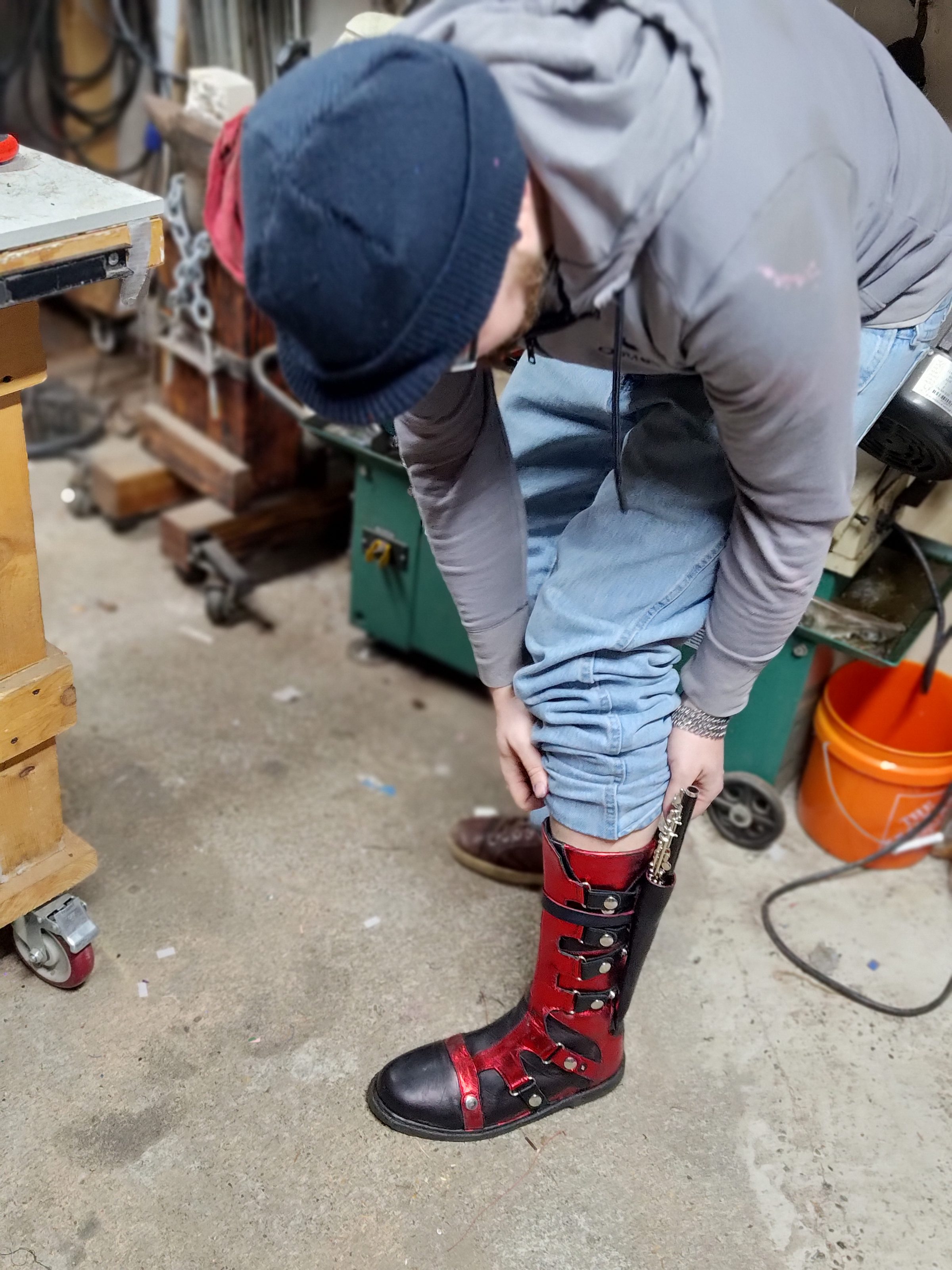 Trying on the hand-made black and red leather boots in the workshop.